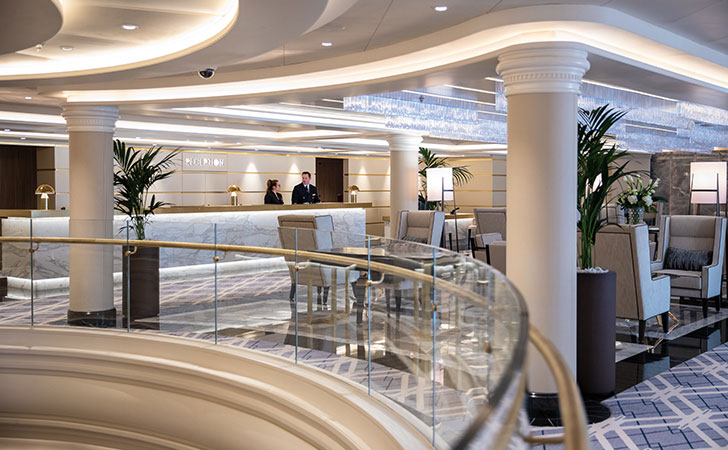 the reception counter with two crew members and a large seating area