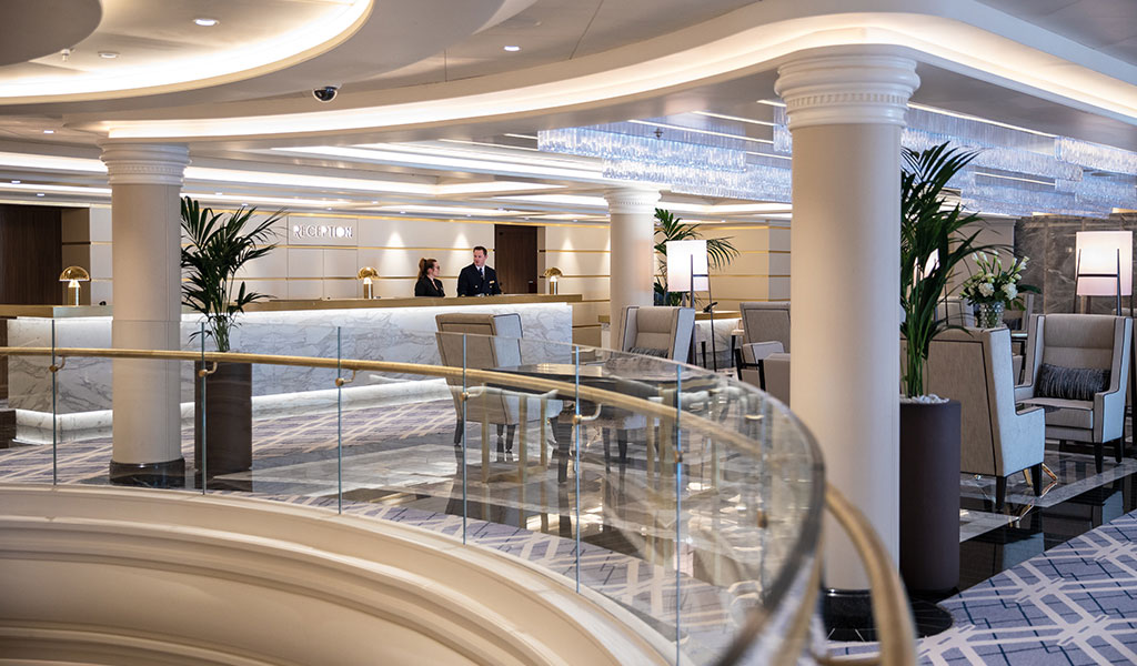 the reception counter with two crew members and a large seating area